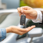 A person hands over car keys to another person, representing Ituran's vehicle security and stolen vehicle recovery services that protect connected cars and provide peace of mind for vehicle owners.